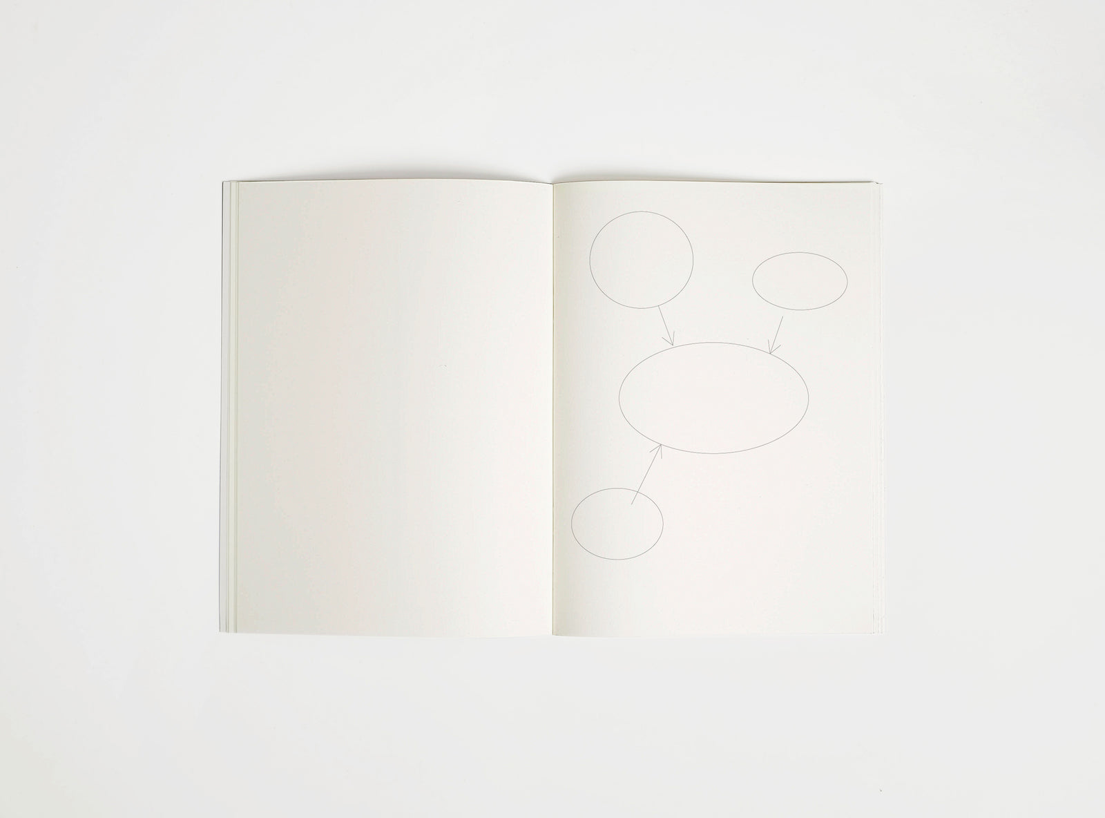 Open notebook edition julie joliat x studio playground with white pages on a white background, with scribbles printed on it.