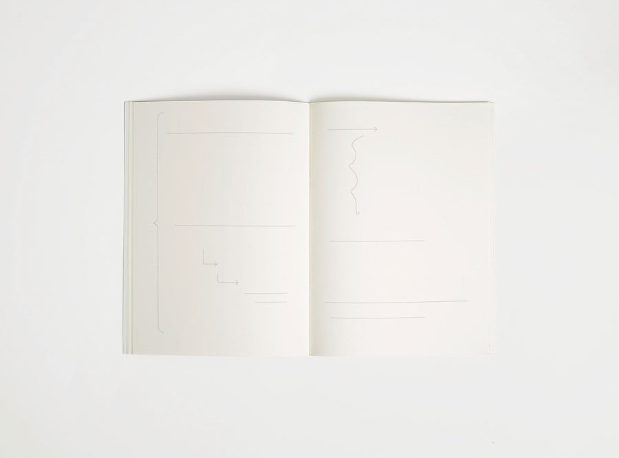 Open notebook edition julie joliat x studio playground with white pages on a white background, with scribbles printed on it.