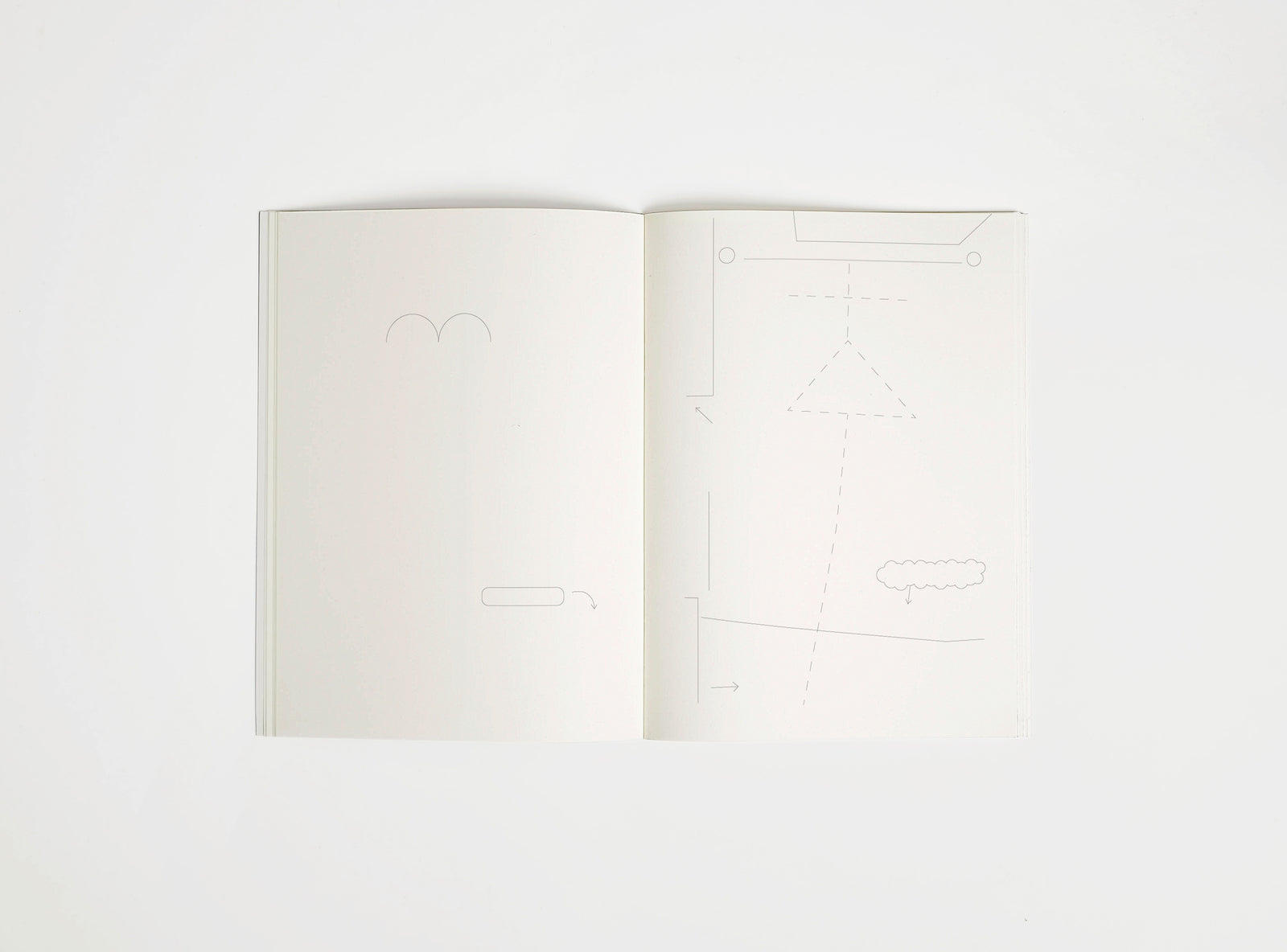 Open notebook edition julie joliat x studio playground with white pages on a white background, with scribbles printed on it.