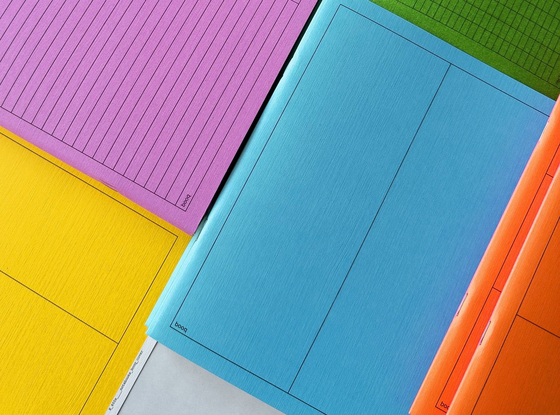 Colorful notebooks booq including pink, blue, green, yellow, and orange on a white background.