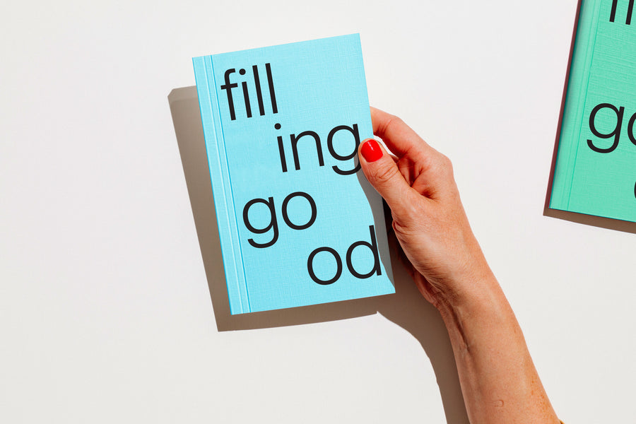 Hand holding a light blue notebook with text on a white background
