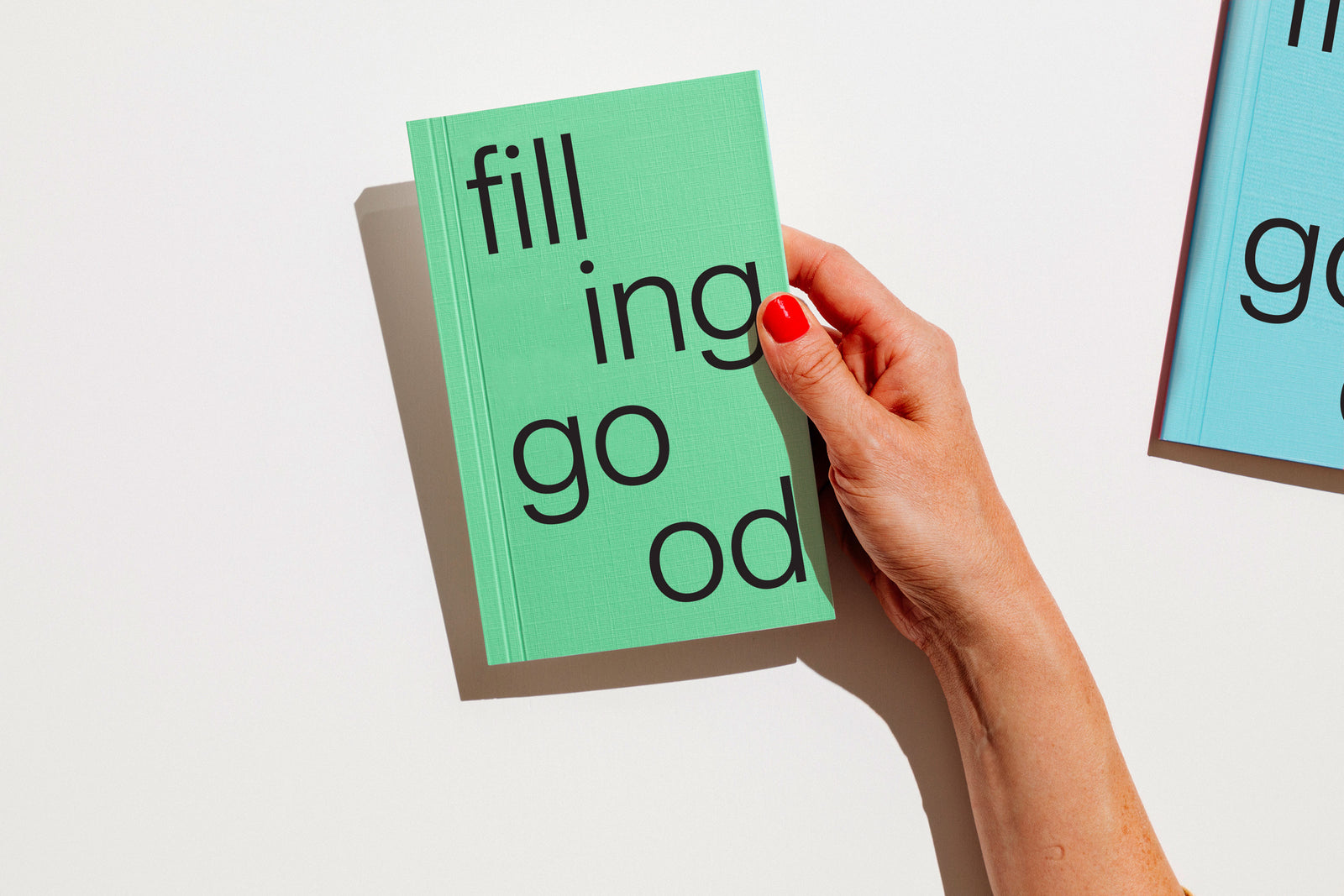Hand holding a green notebook with text on a white background