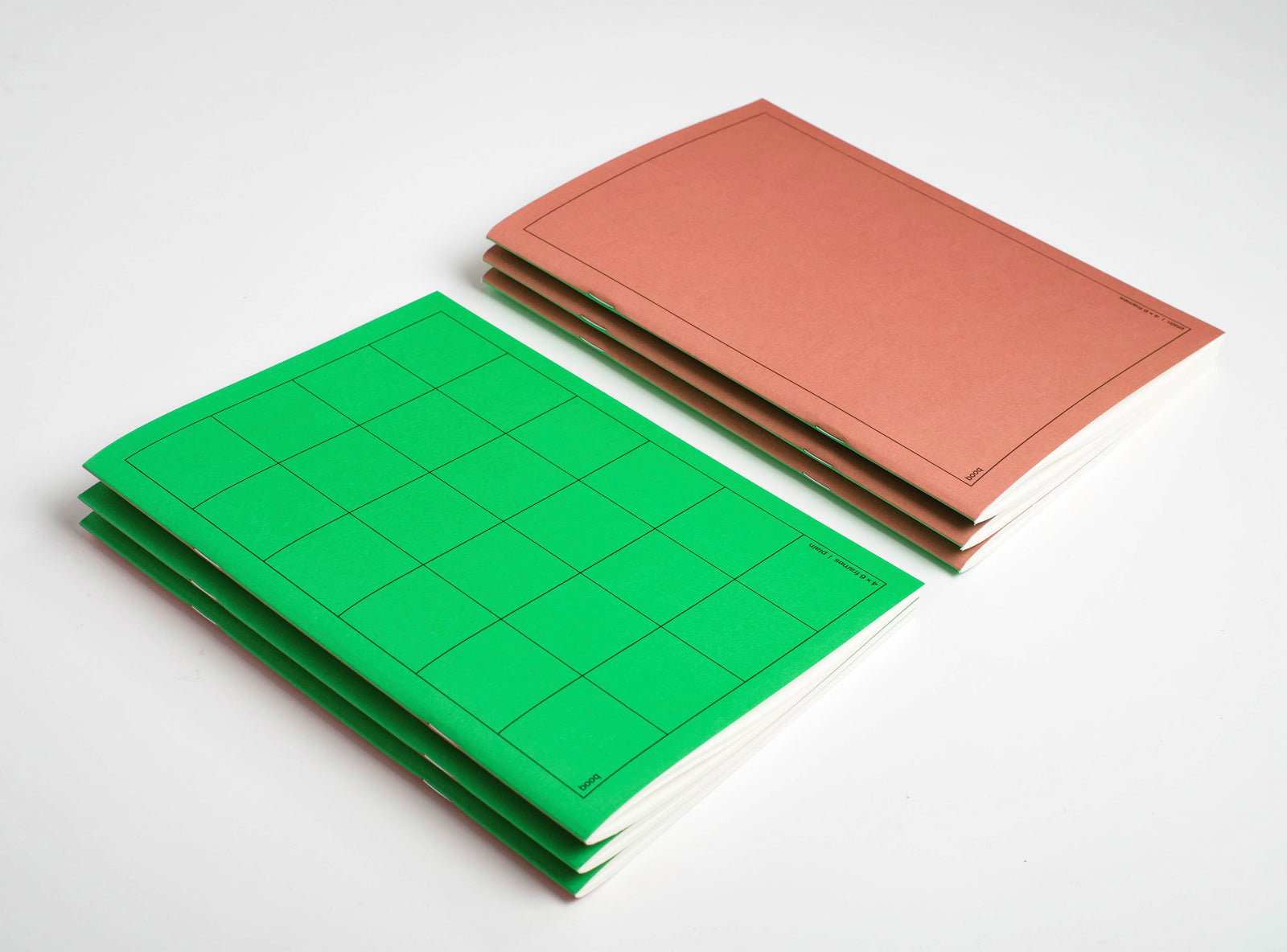 1 green and one brown pile of notebooks booq on a white background