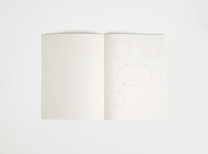 Open notebook edition julie joliat x studio playground with white pages on a white background, with scribbles printed on it.
