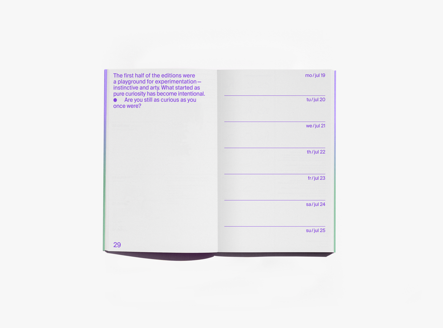 An open edition julie joliat planner agenda 2027 showing a page with purple text on the left and a weekly schedule layout on the right, photographed on a clean white background.